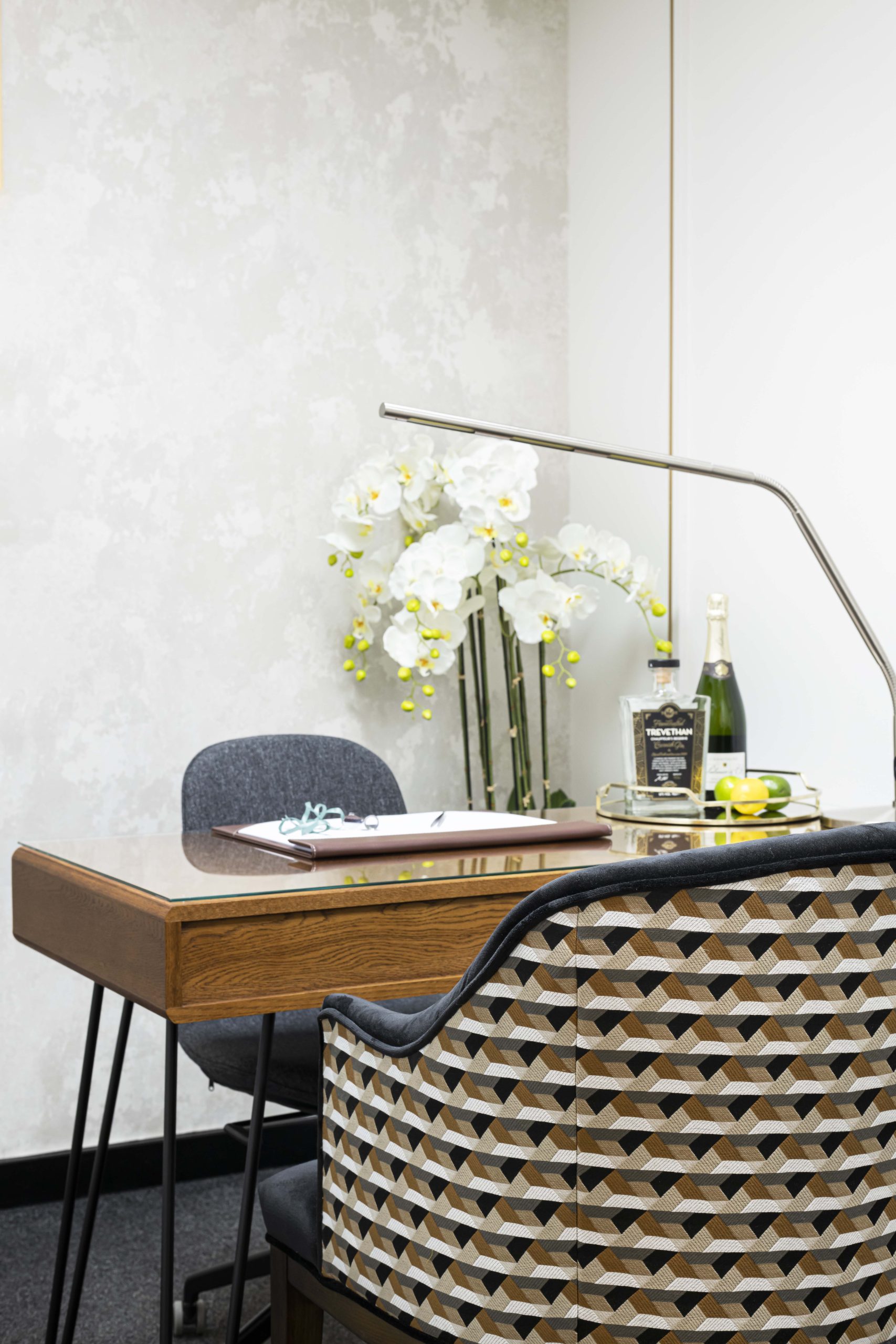 A viewing room desk seen from the doorway, with fresh flowers and a single chair