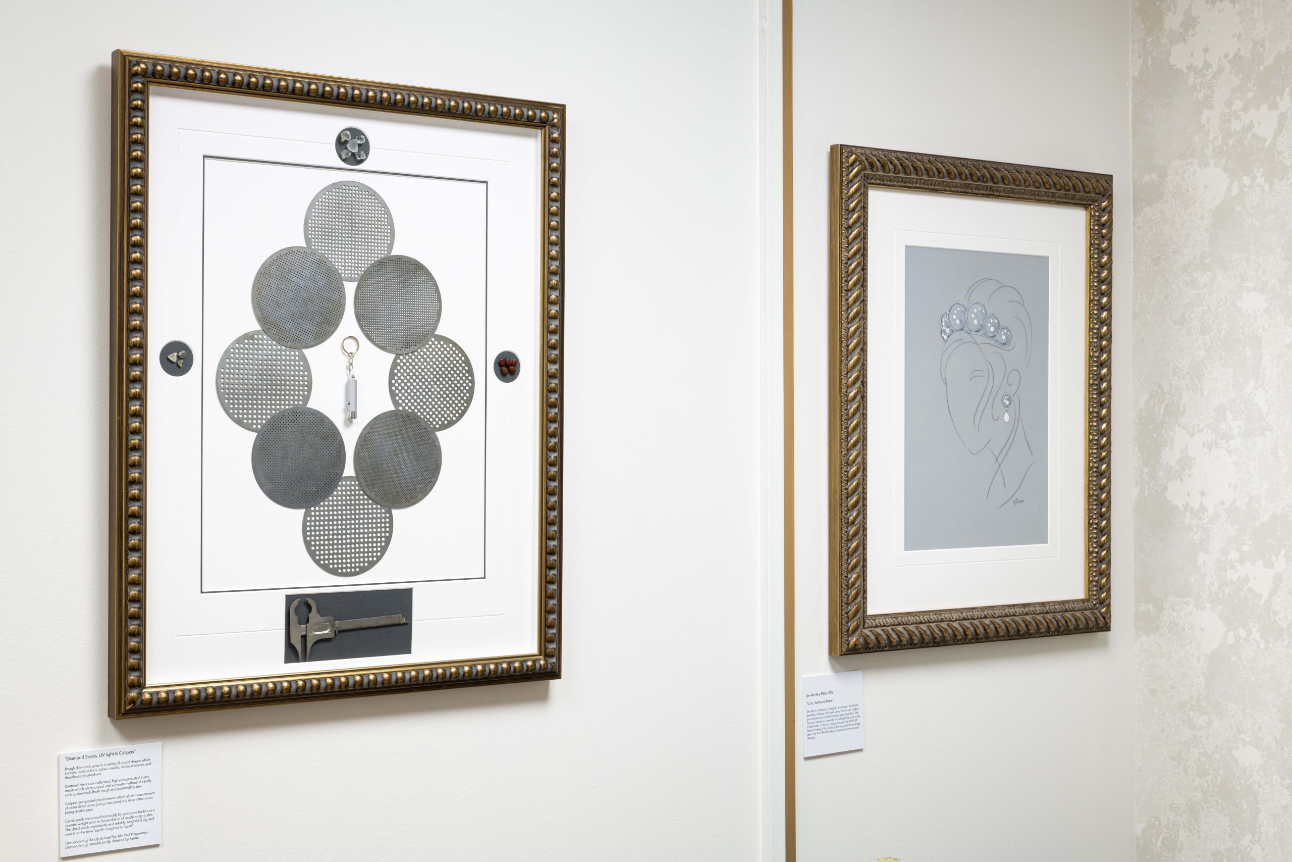 Framed diamond cut and clarity reference charts hanging on a viewing room wall